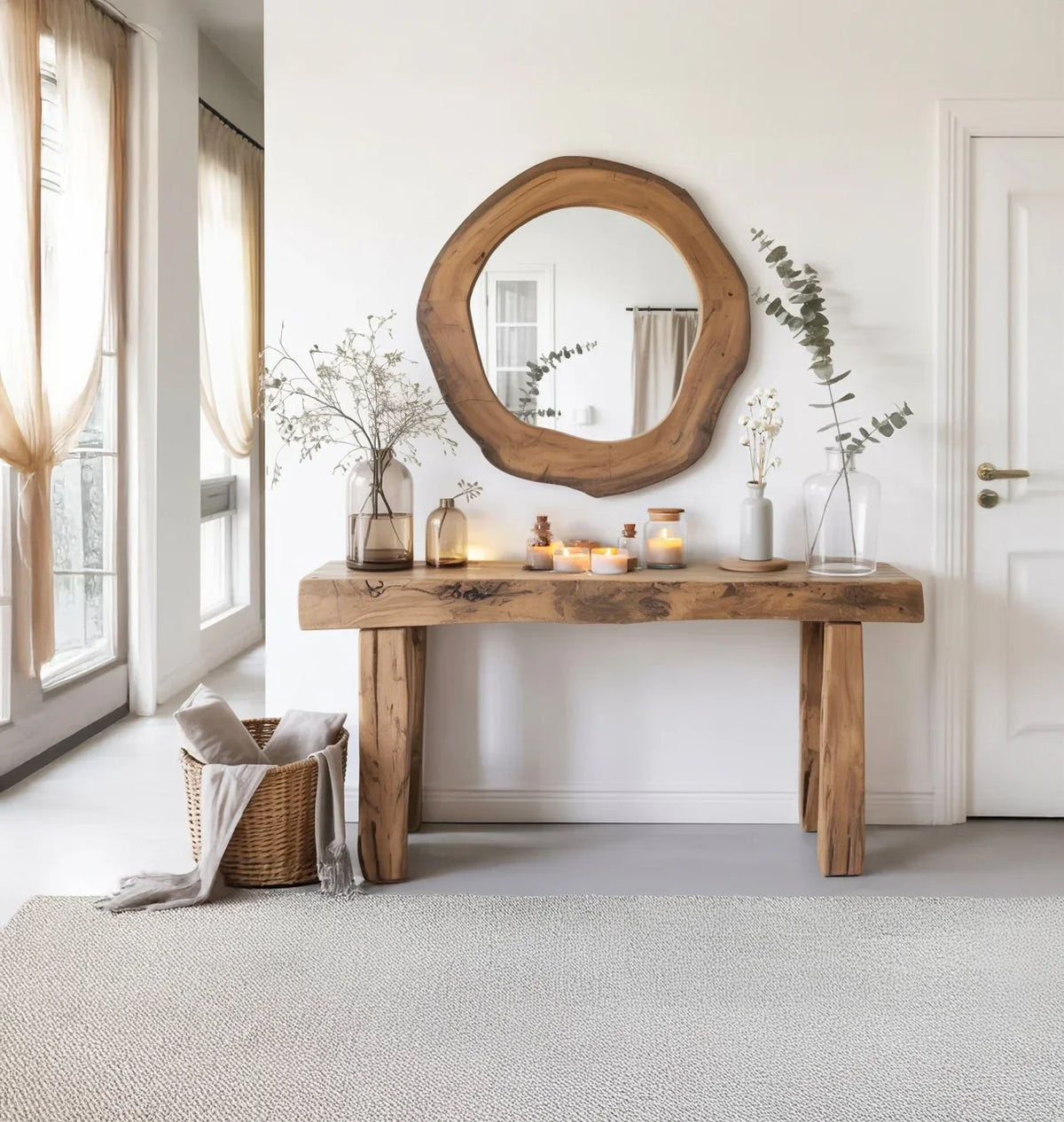 Solid wood live edge console table with round mirror, candles, and vases in a bright entryway