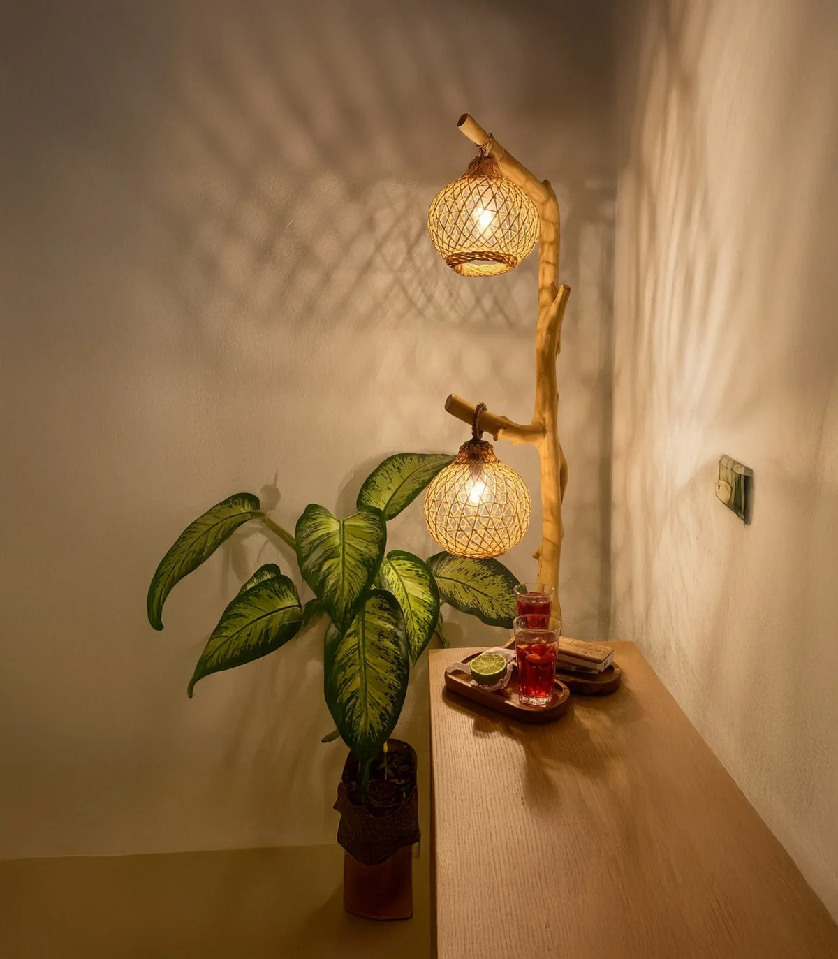 Cozy corner with a live edge wood table, potted plant, bamboo floor lamp, and drinks tray.