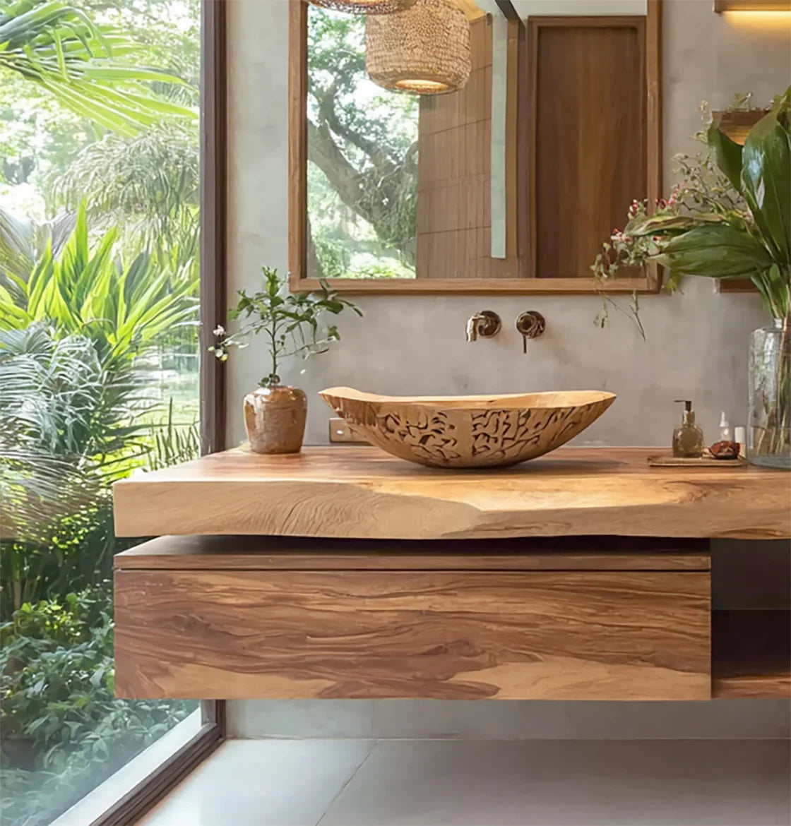 Modern wooden bathroom vanity with carved vessel sink, large mirror, and lush greenery outside window