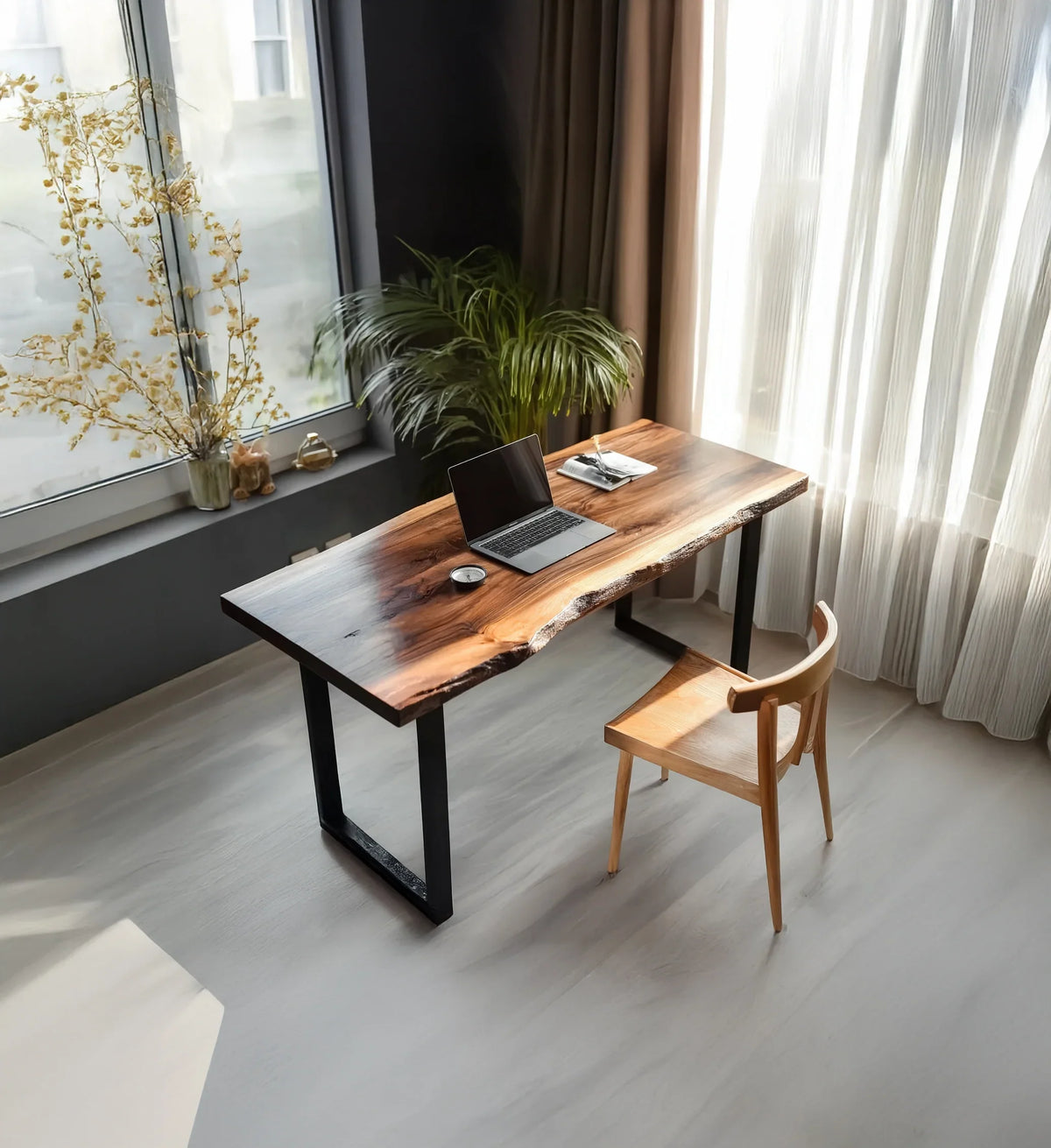 Modern wooden desk with laptop and plant near window in bright minimalist home office