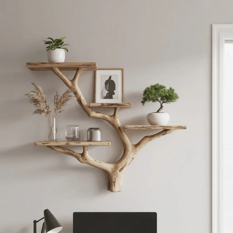 Wall-mounted live edge wood tree bookshelf with plants and decor above desk
