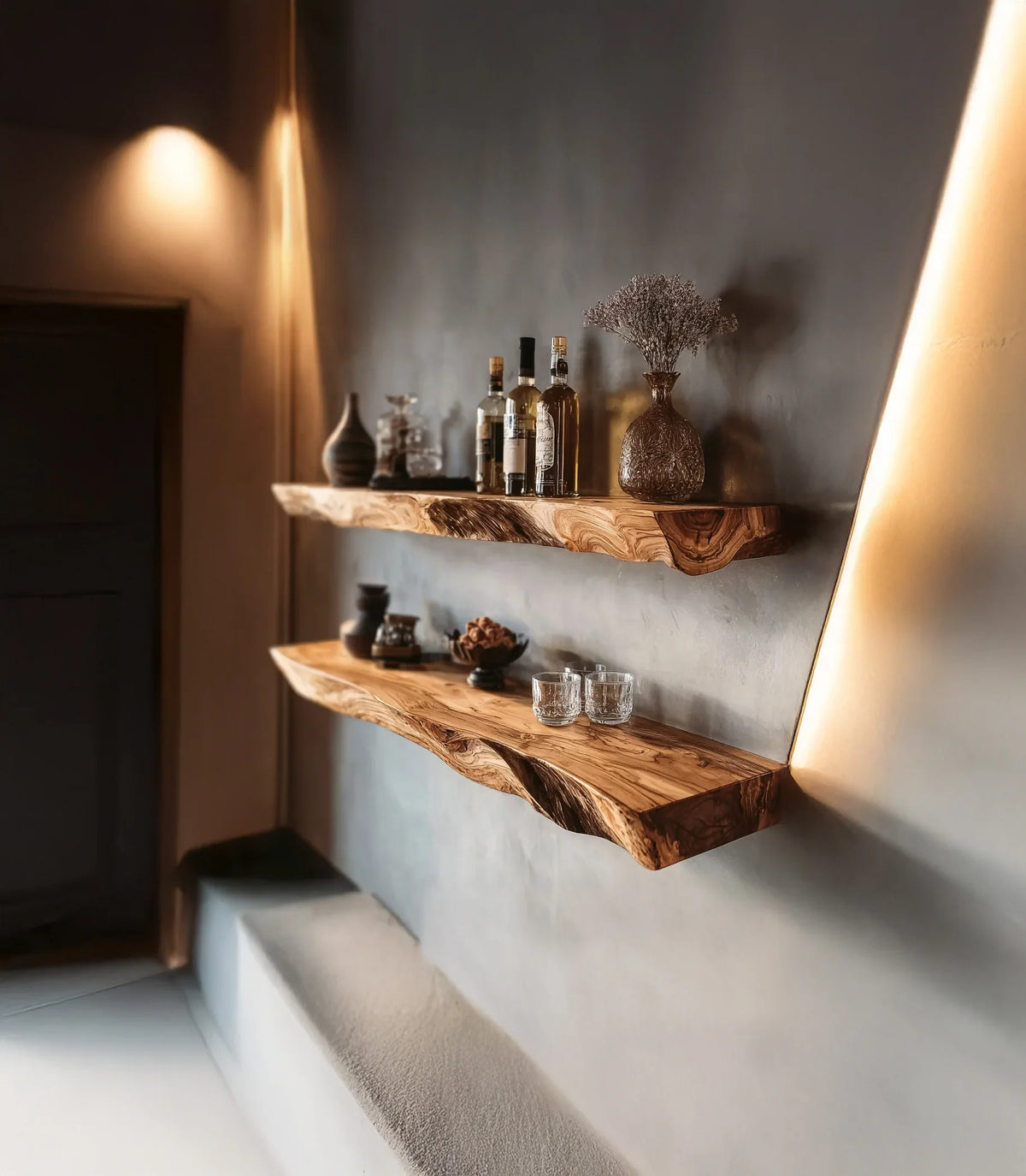 Rustic wooden floating shelves with glass bottles, decorative vases, and glasses on gray wall