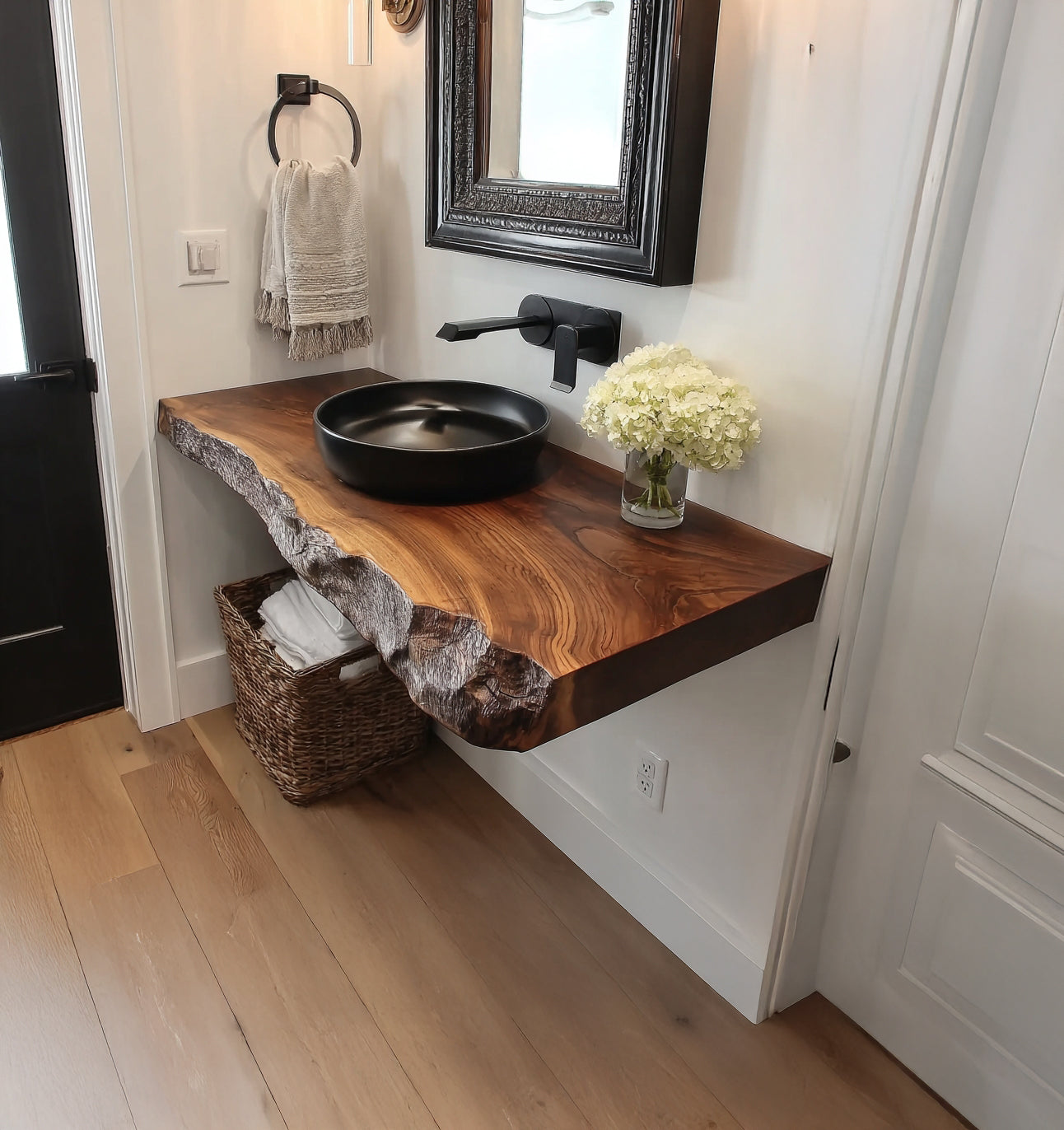Modern bathroom with live edge wooden floating vanity, black vessel sink, and white flowers