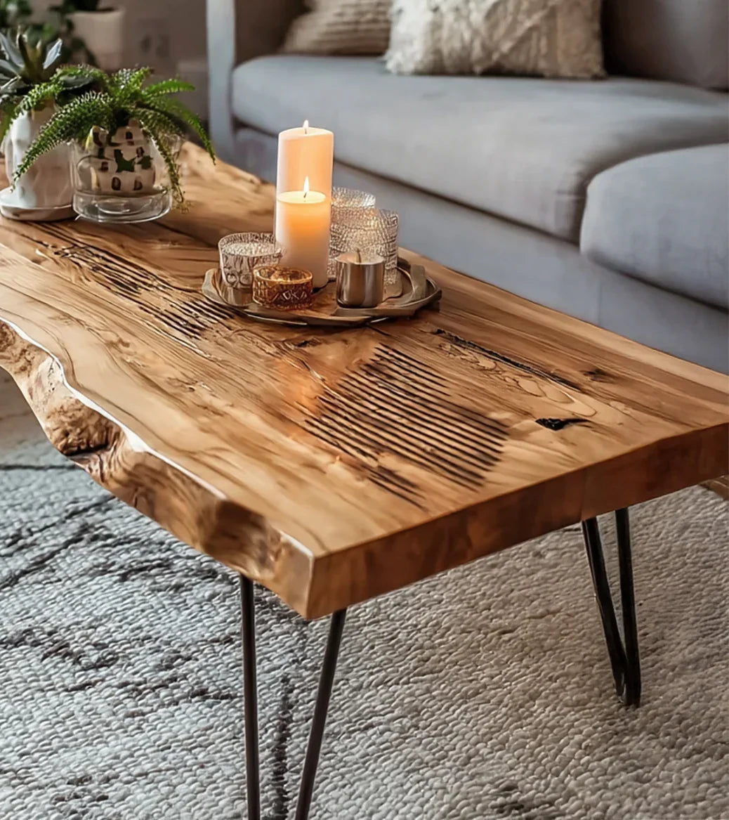 Live edge wooden coffee table with black metal legs holding lit candles and decorative plants in cozy living room