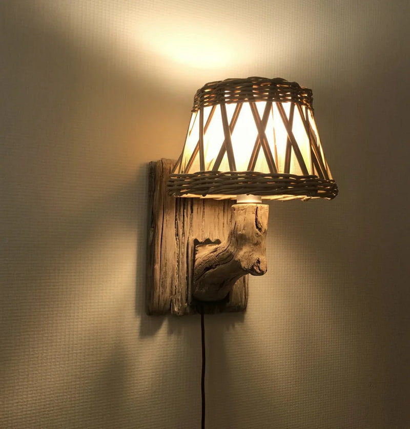 Rustic wall lamp with wicker lampshade and wooden base mounted on textured wall