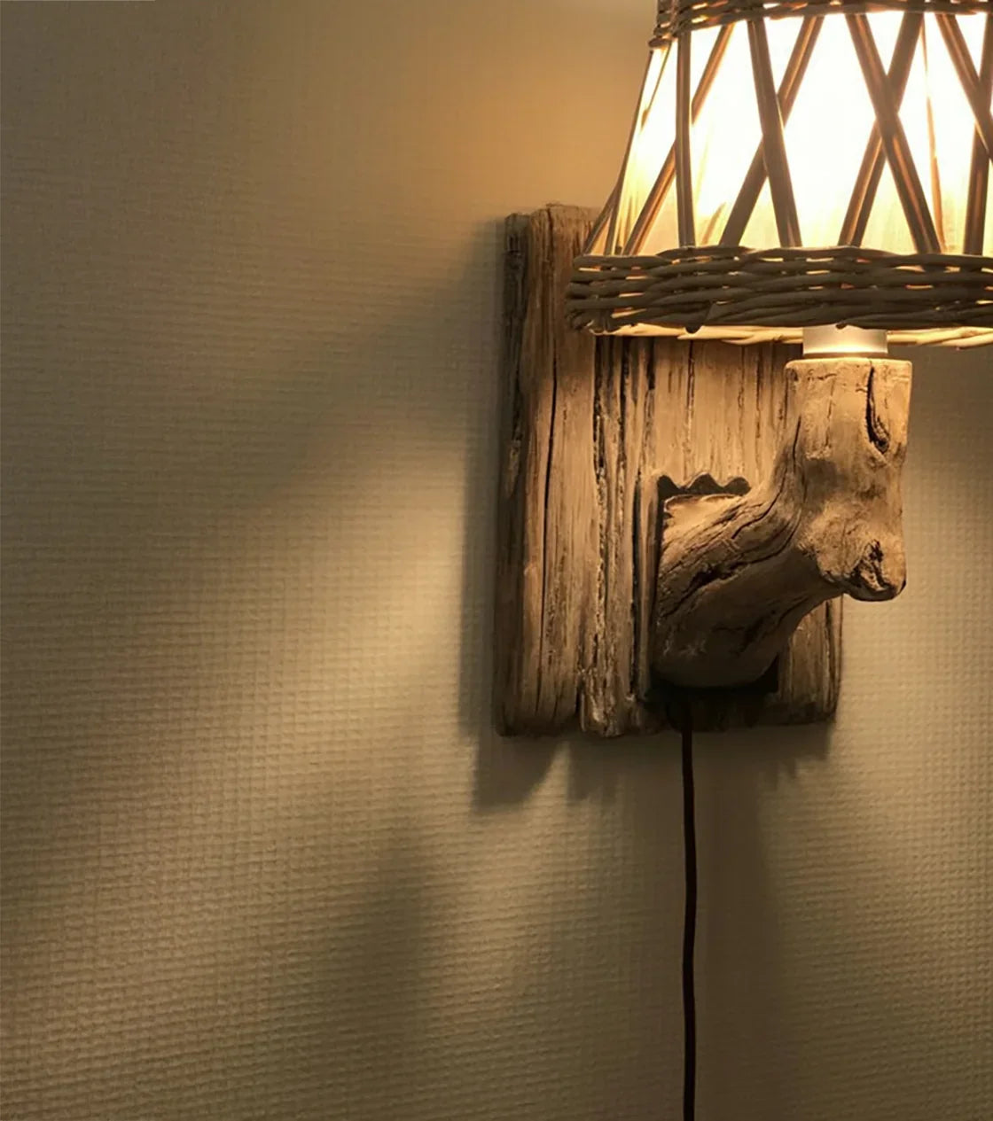 Wall lamp with a rustic wooden base and woven wicker lampshade casting warm light on textured wall