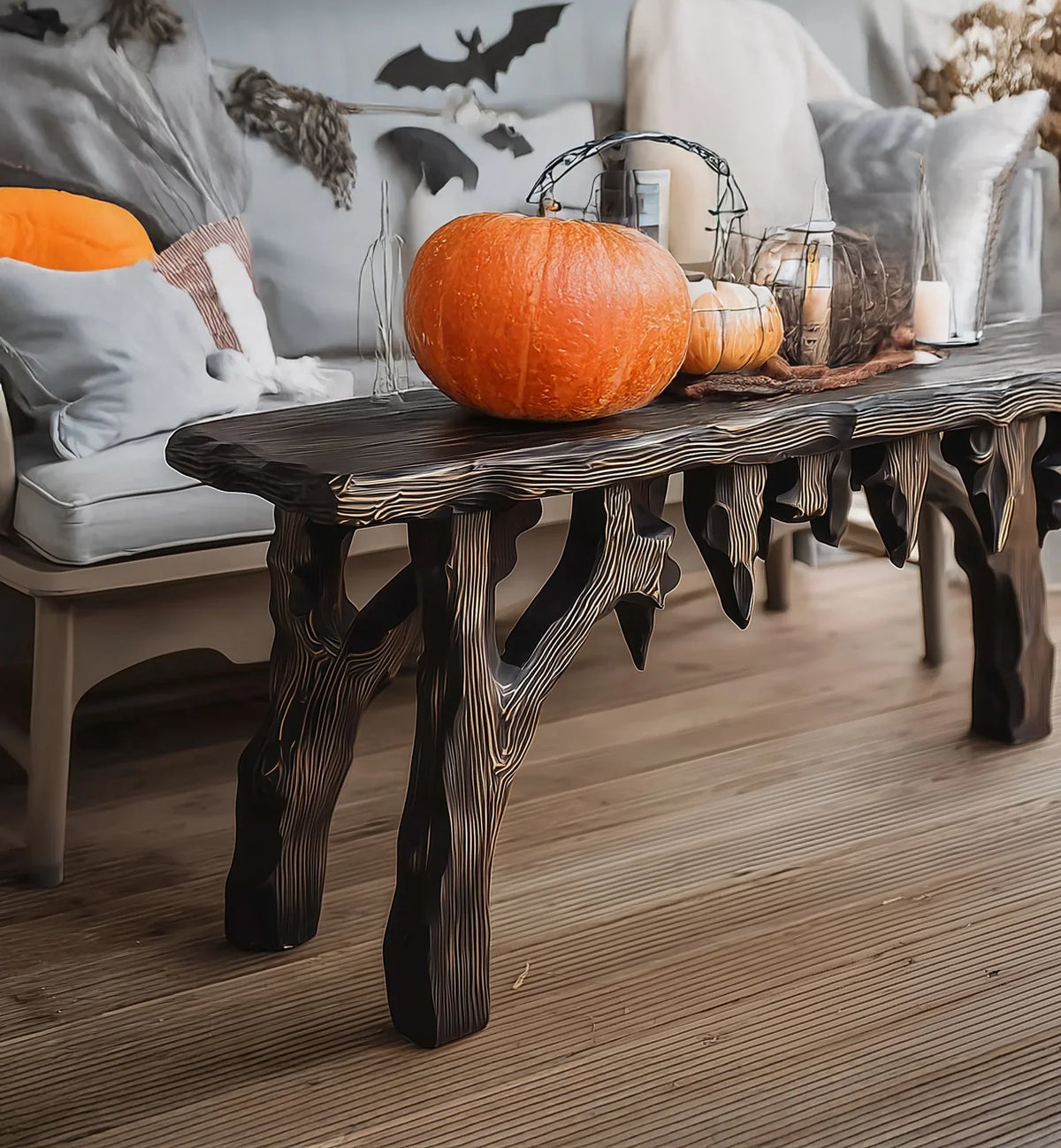 Live edge solid wood coffee table with carved legs, pumpkins and candles in cozy living room