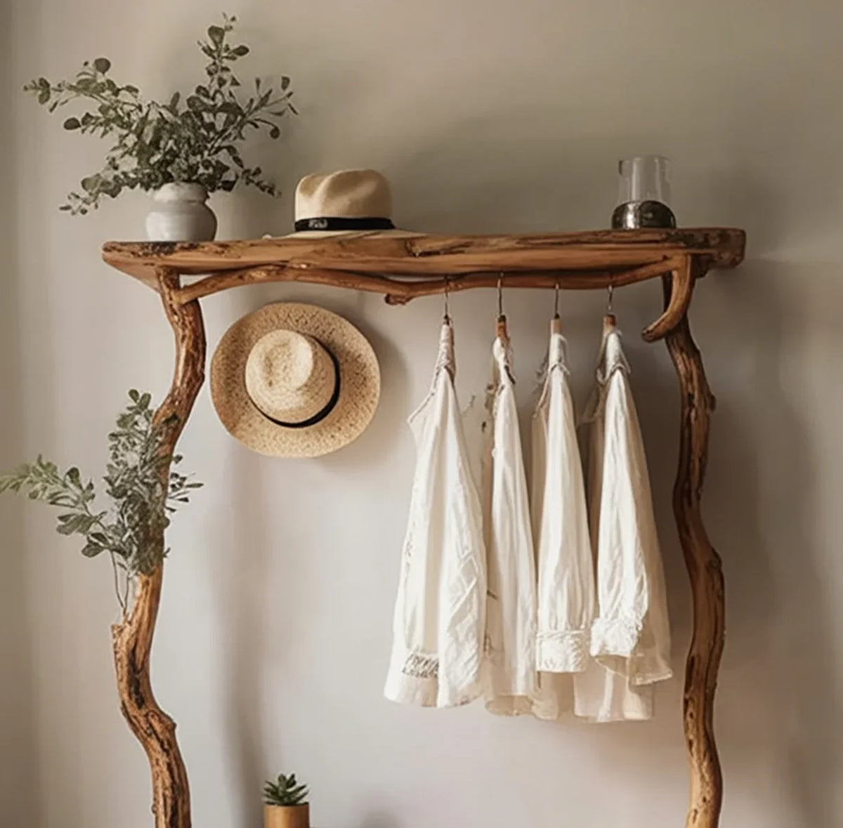 Live edge solid wood coat rack with hanging white shirts, hat, plants, and decor