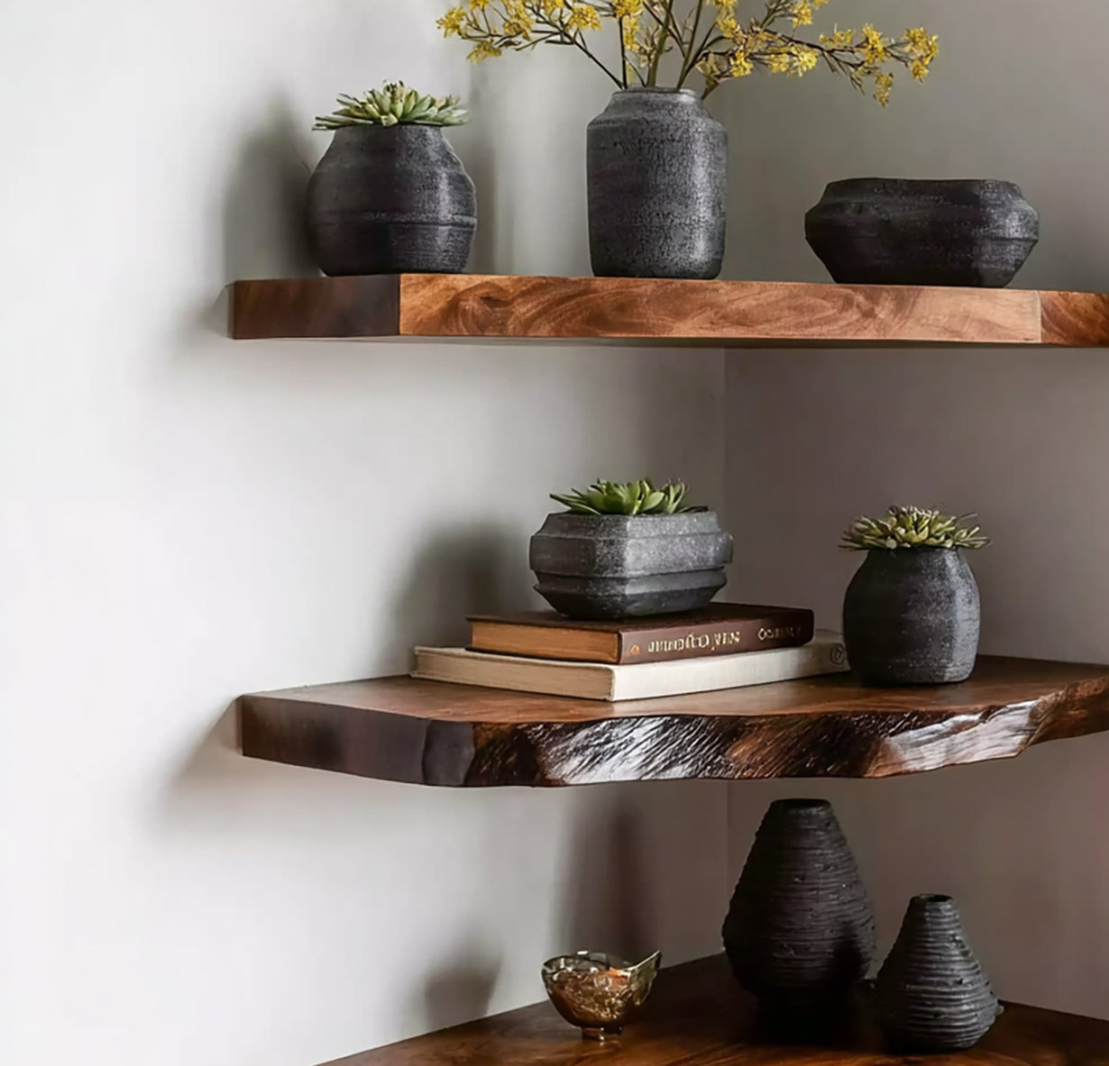 Live edge solid wood floating shelves with black ceramic vases and small succulents