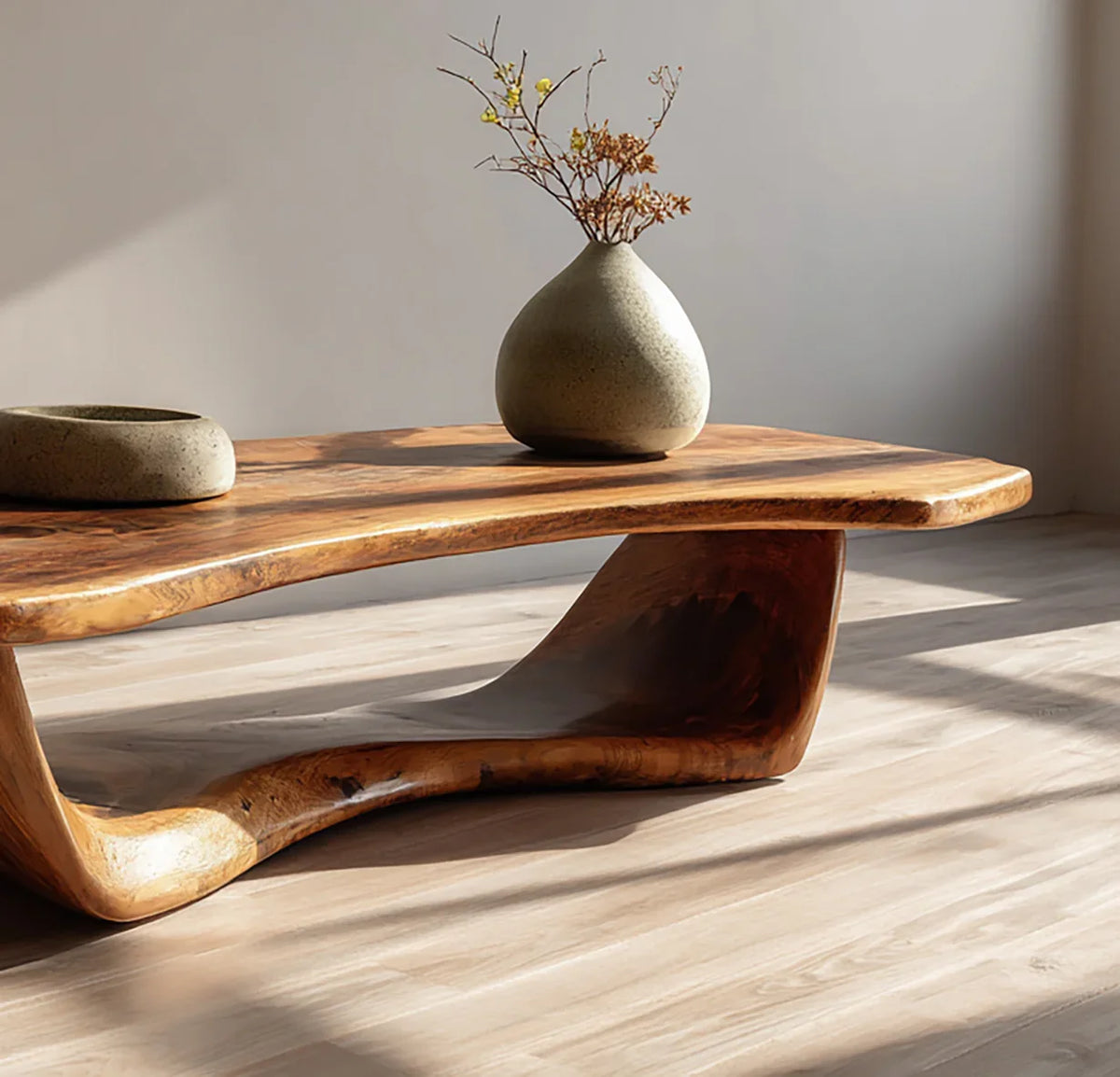 Live edge solid wood coffee table with modern sculptural base, ceramic vase decor