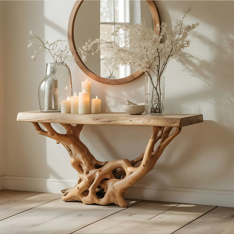 Live edge wood console table with sculpted tree root base, candles, vases, and round mirror
