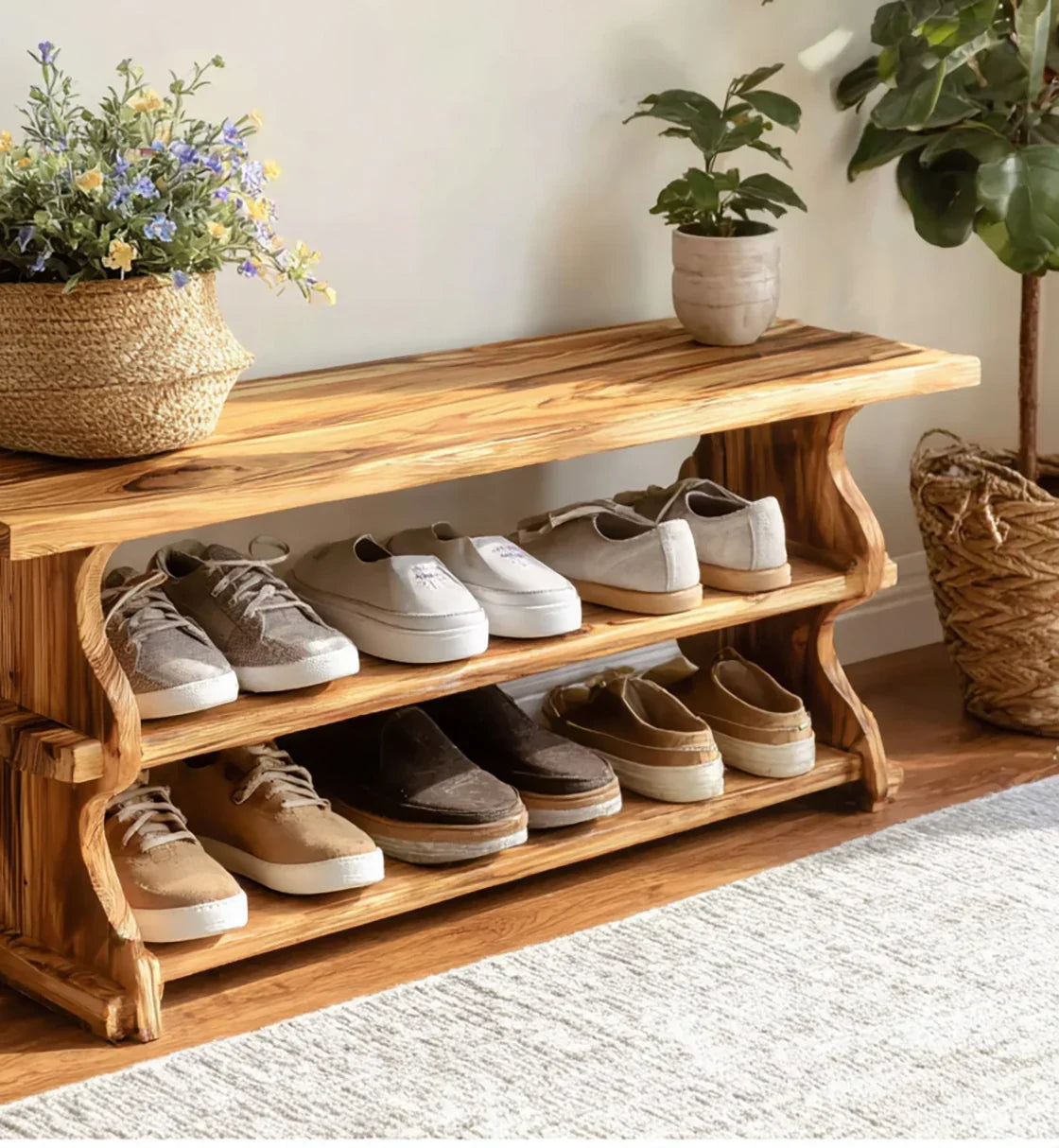 Solid wood shoe bench with live edge design, holding shoes and decorated with potted plants.
