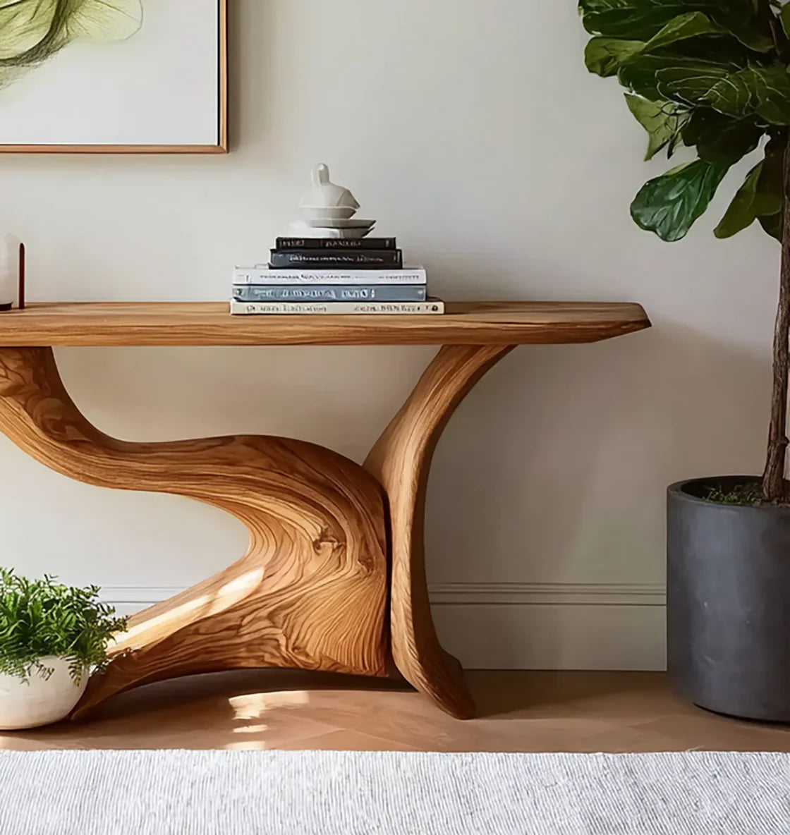 Live edge wooden console table with sculptural base, books, and indoor plants in modern room