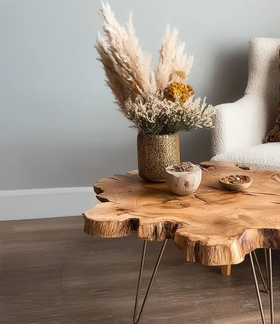 Live edge wooden coffee table with pampas grass arrangement and small bowls in modern living room