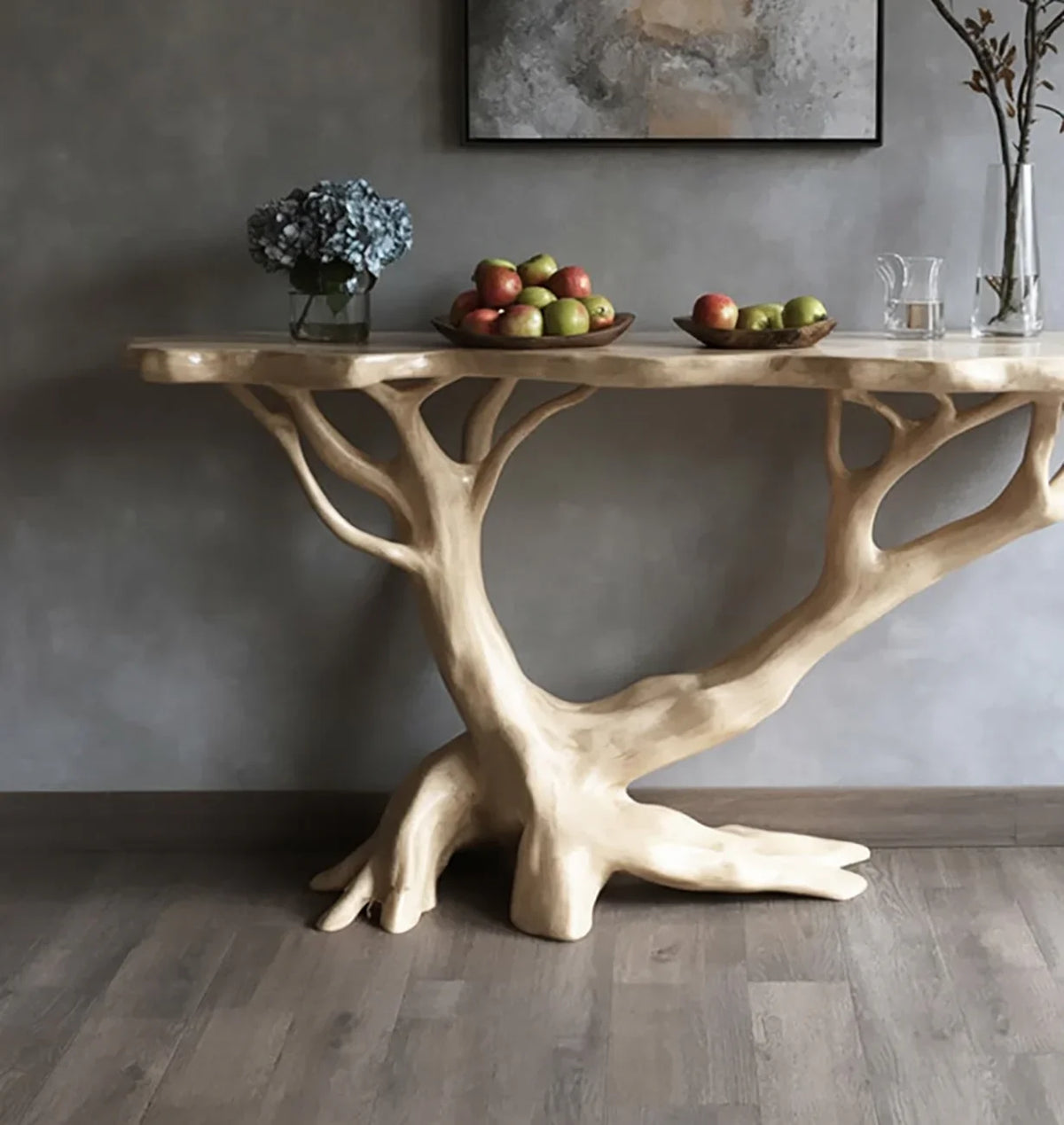 Live edge wood console table with tree-shaped base, fruit bowls, and floral decor