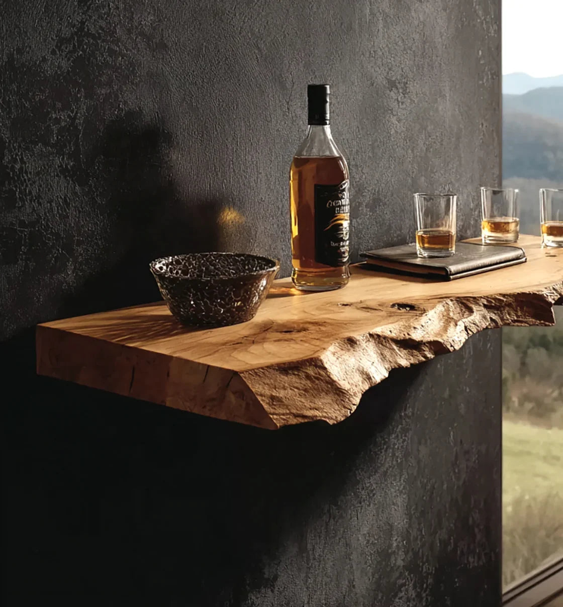Rustic live edge wood shelf with whiskey bottle, glass tumbler drinks, and black bowl on dark textured wall