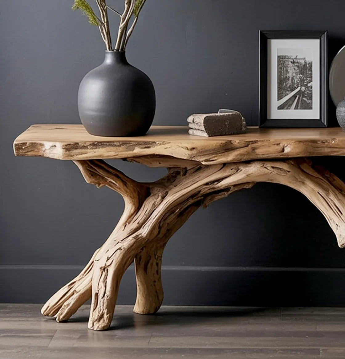 Rustic wooden console table with natural driftwood base against gray wall, decorated with black vase and photo frame
