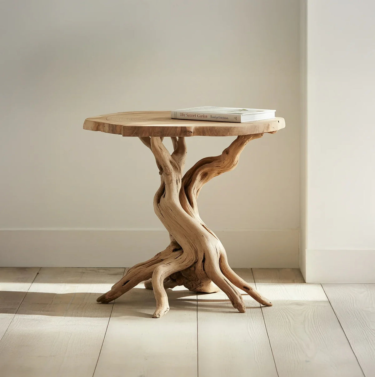 Rustic wooden side table with natural twisted branch base and book on top in bright room
