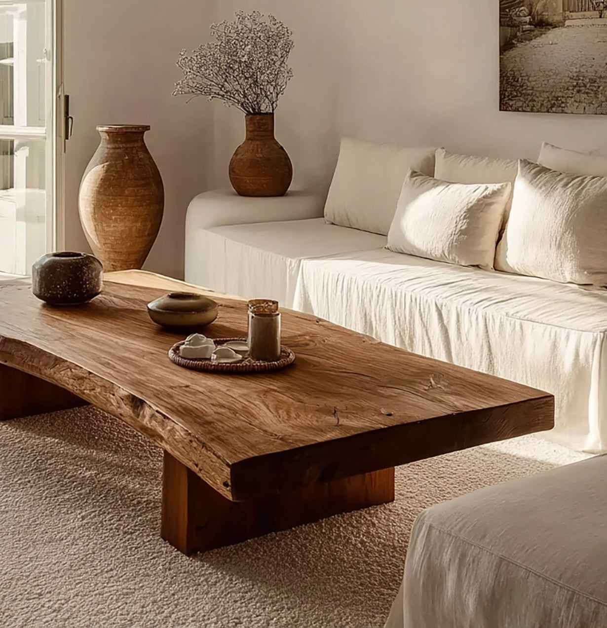 Minimalist living room with natural wood coffee table, white sofa, and rustic ceramic vases