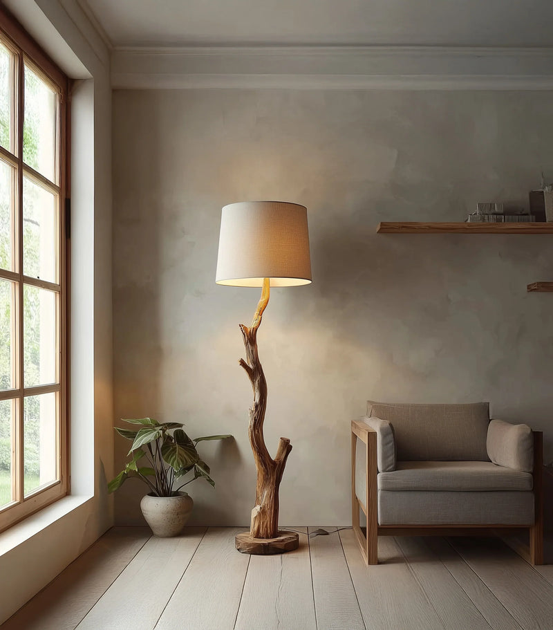 Live edge wood floor lamp with natural branch base, next to modern armchair in bright room