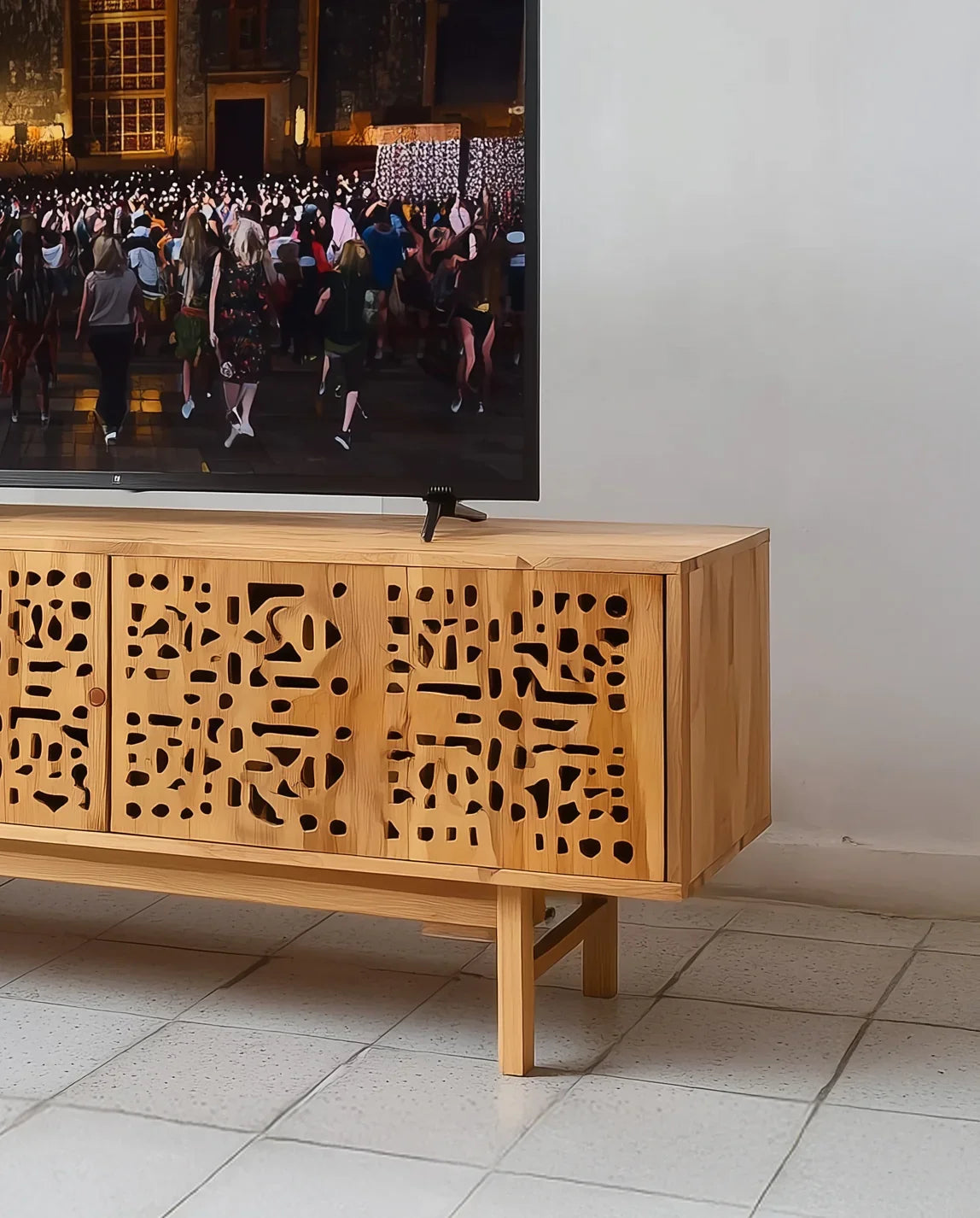 Solid wood TV console with geometric cutout doors on tile floor