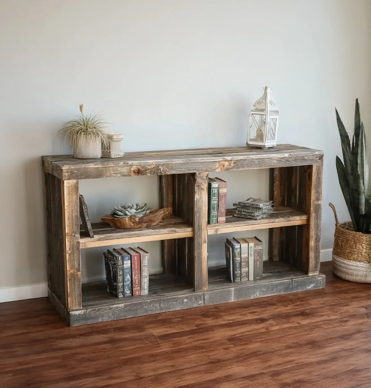 Rustic solid wood bookshelf with books, succulents, and decor, on wood floor.