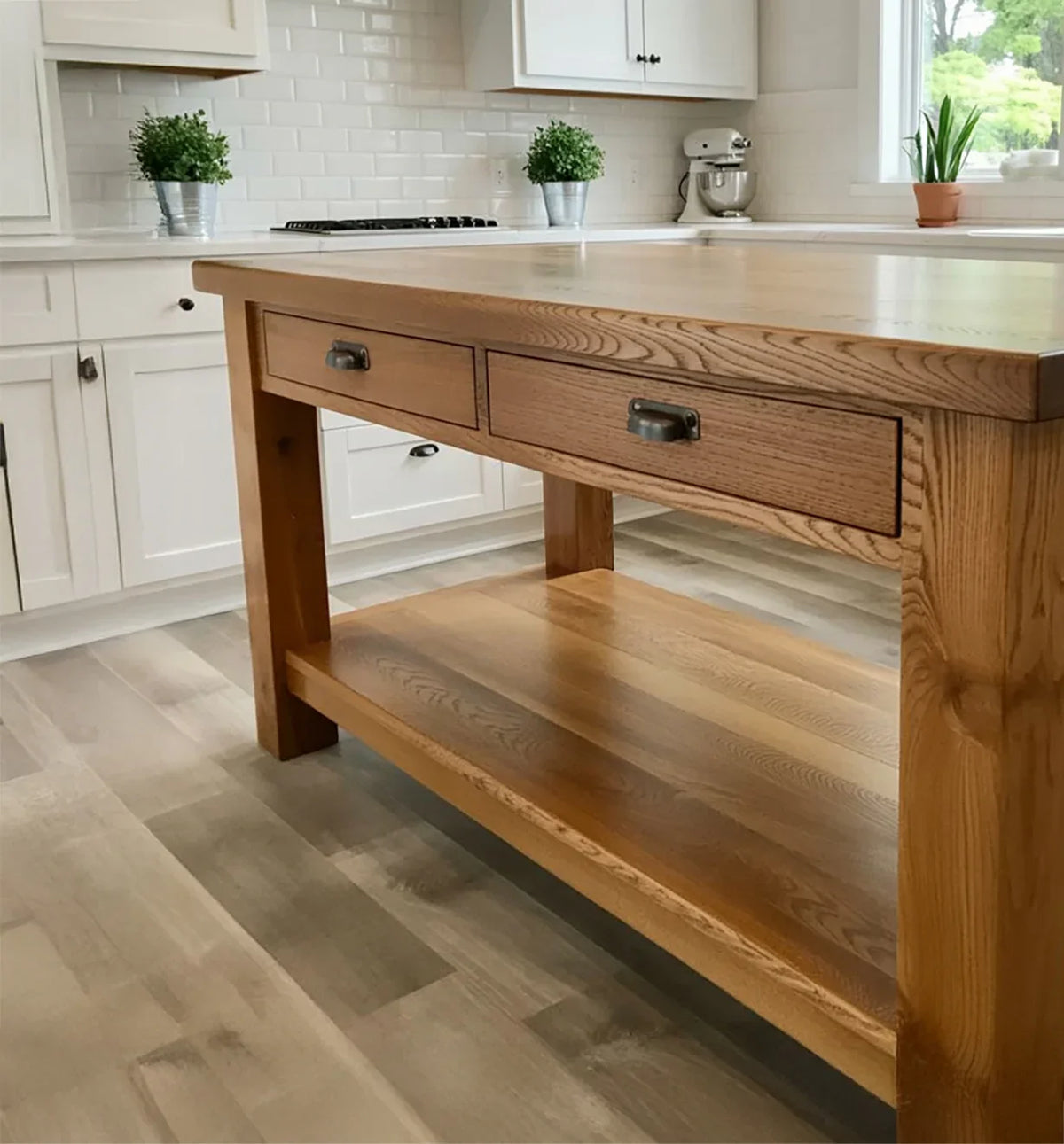 Solid wood kitchen island with drawers on light wood floor in modern white kitchen