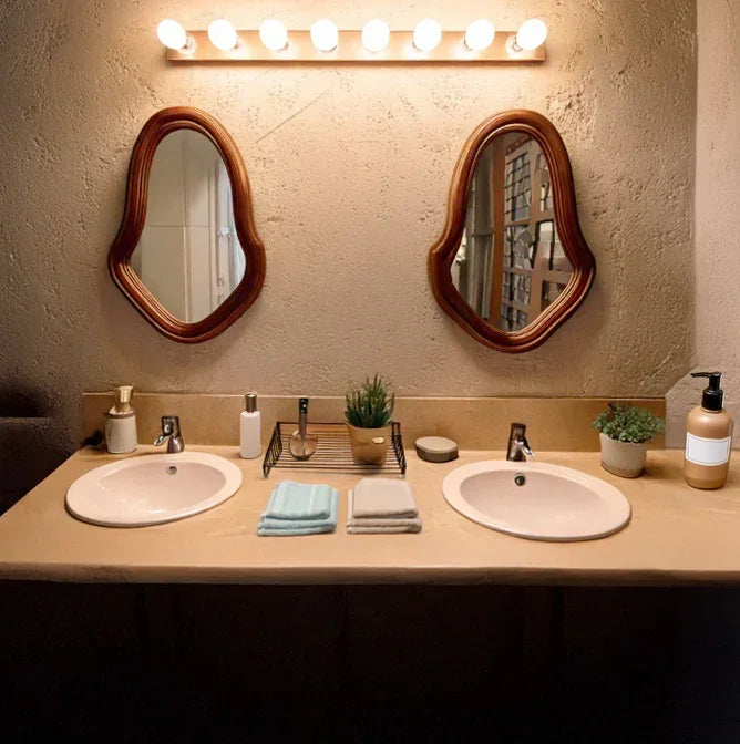 Double bathroom vanity with two sinks, wooden mirrors, plants, and modern lighting