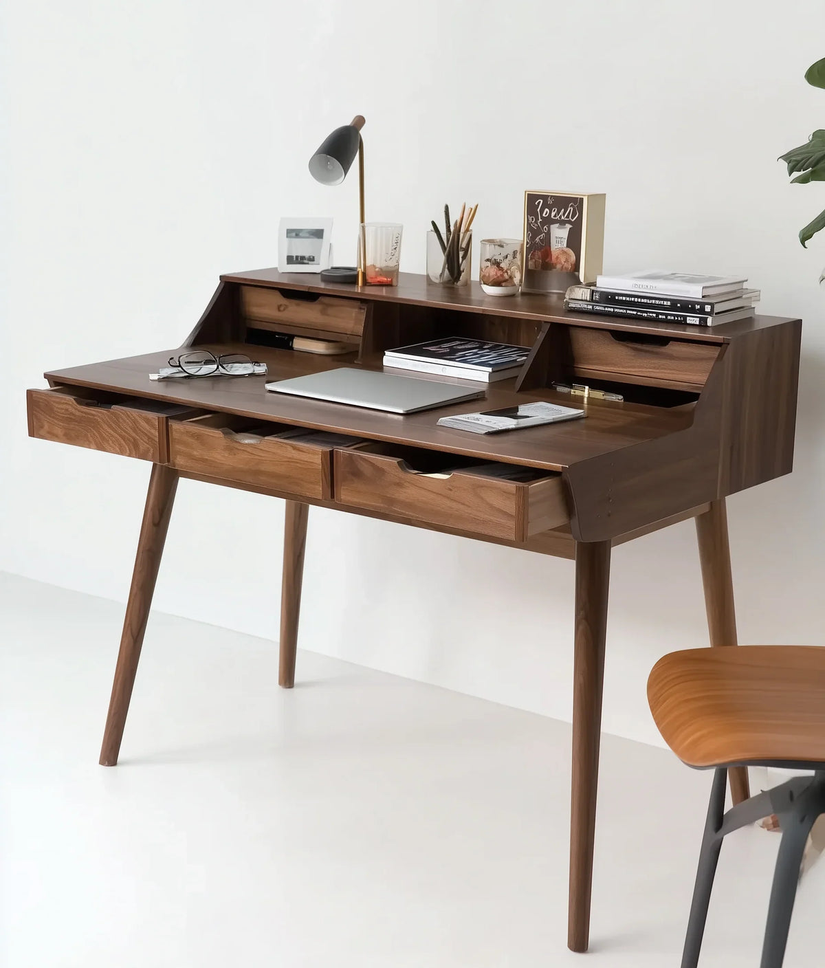 Mid-century modern solid wood desk with drawers and open shelves, styled with office accessories