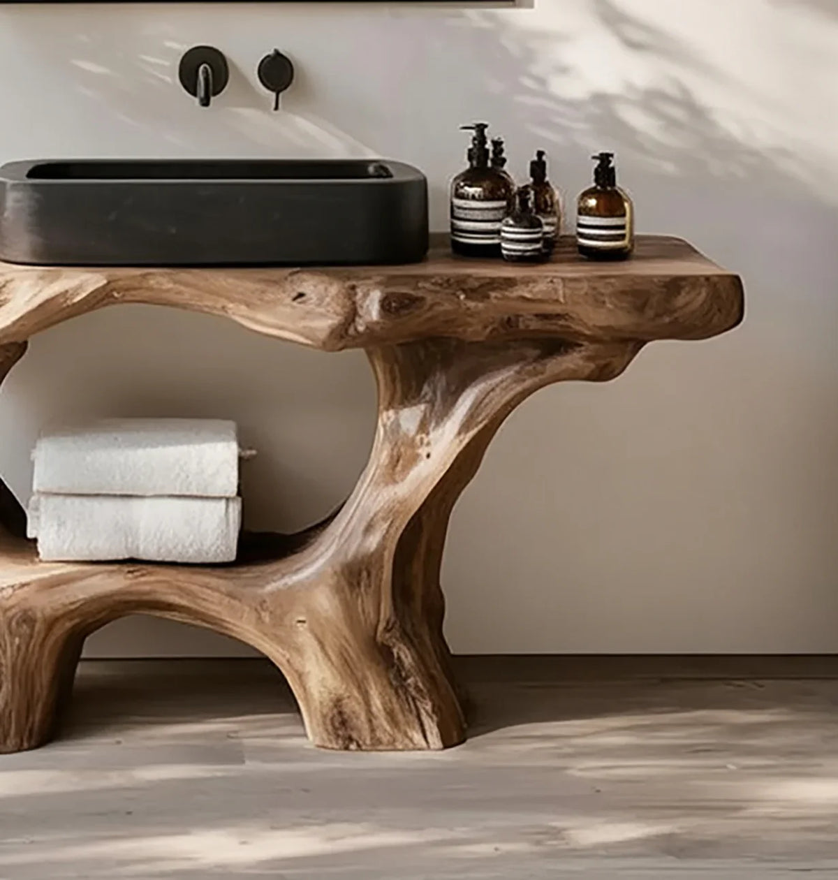 Live edge solid wood bathroom vanity with black vessel sink, towels, and soap dispensers
