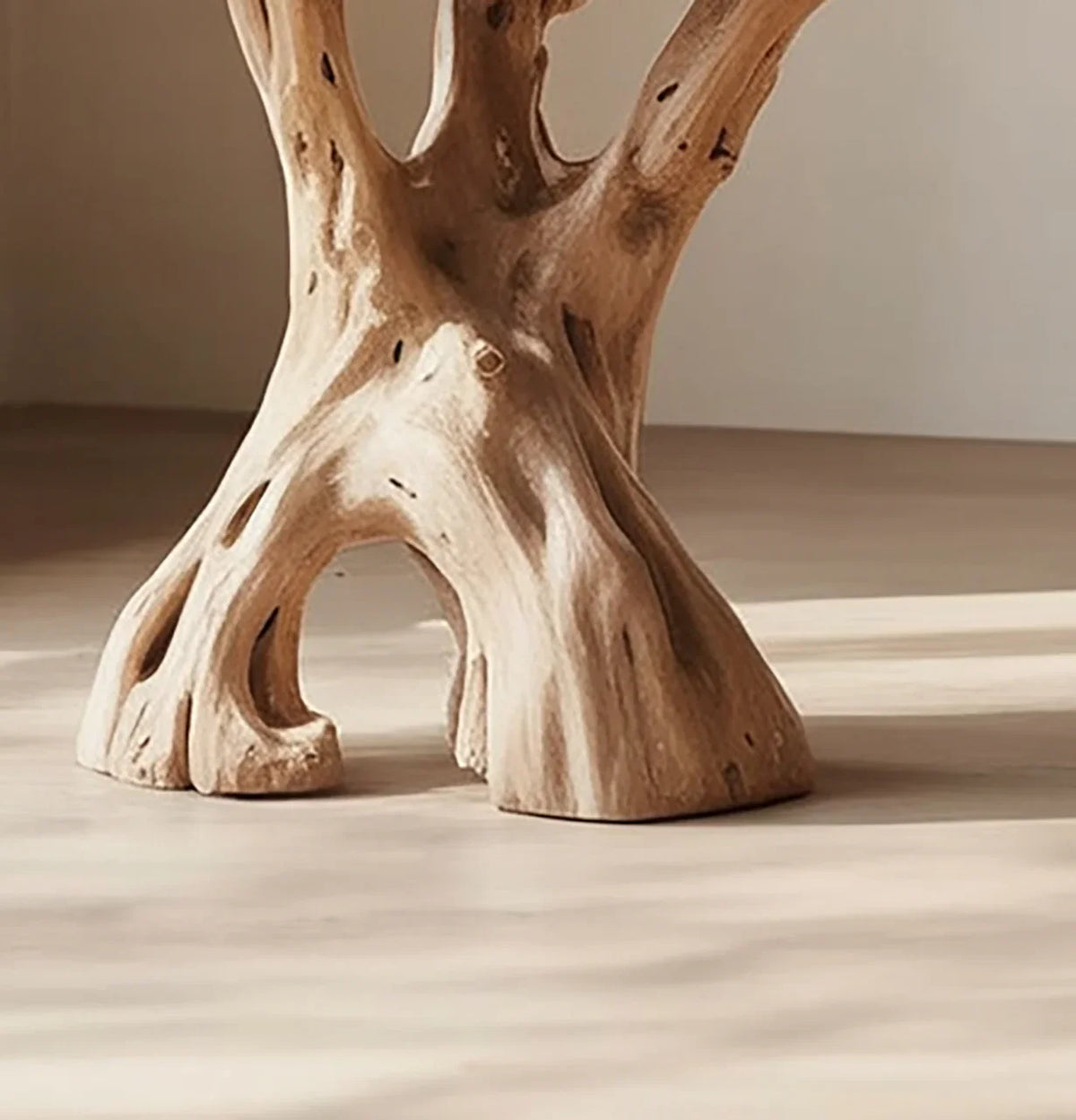 Close-up of live edge solid wood table base with natural tree trunk shape on light floor