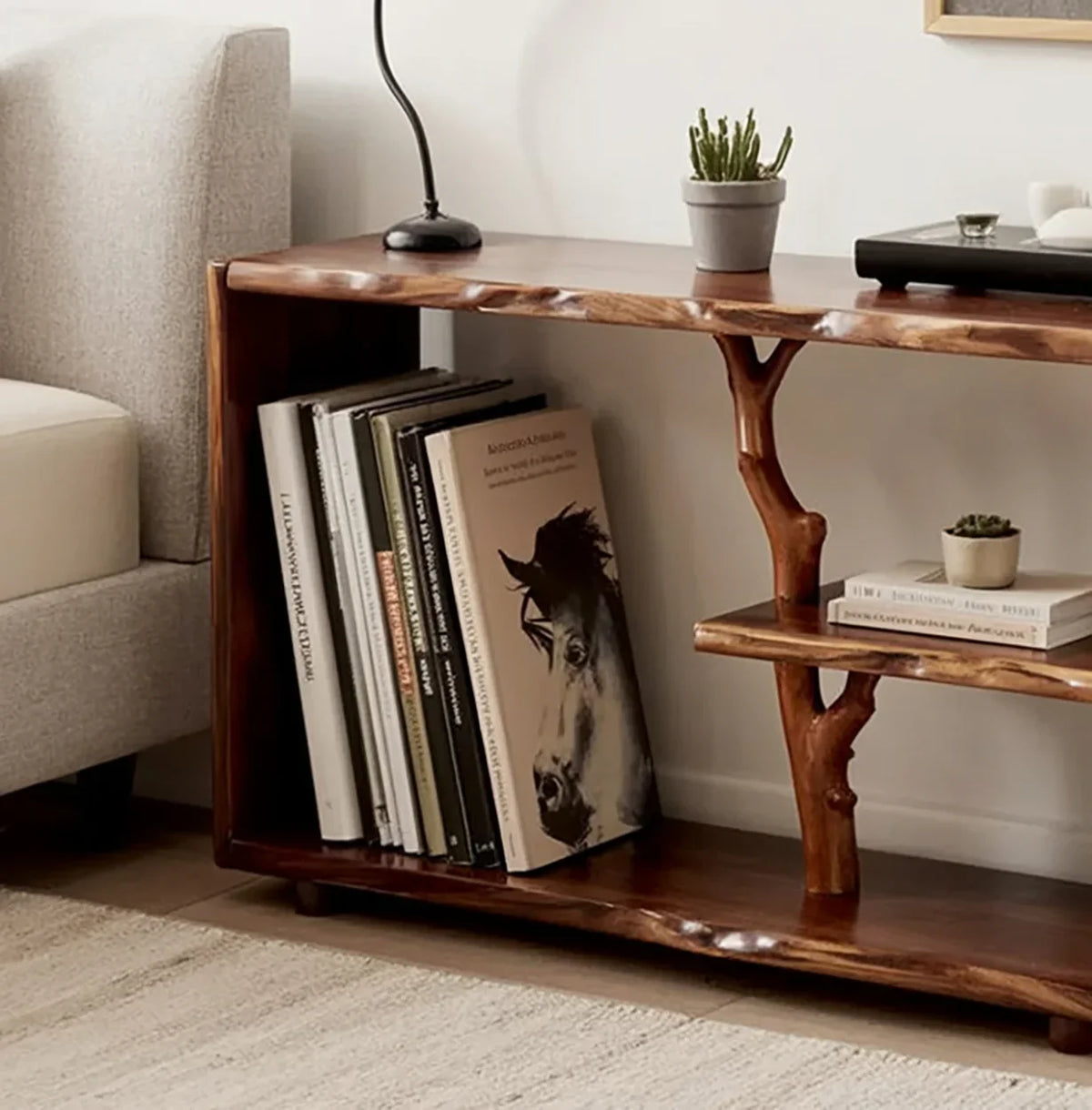 Live edge solid wood bookshelf with books, potted succulents, and unique tree branch support