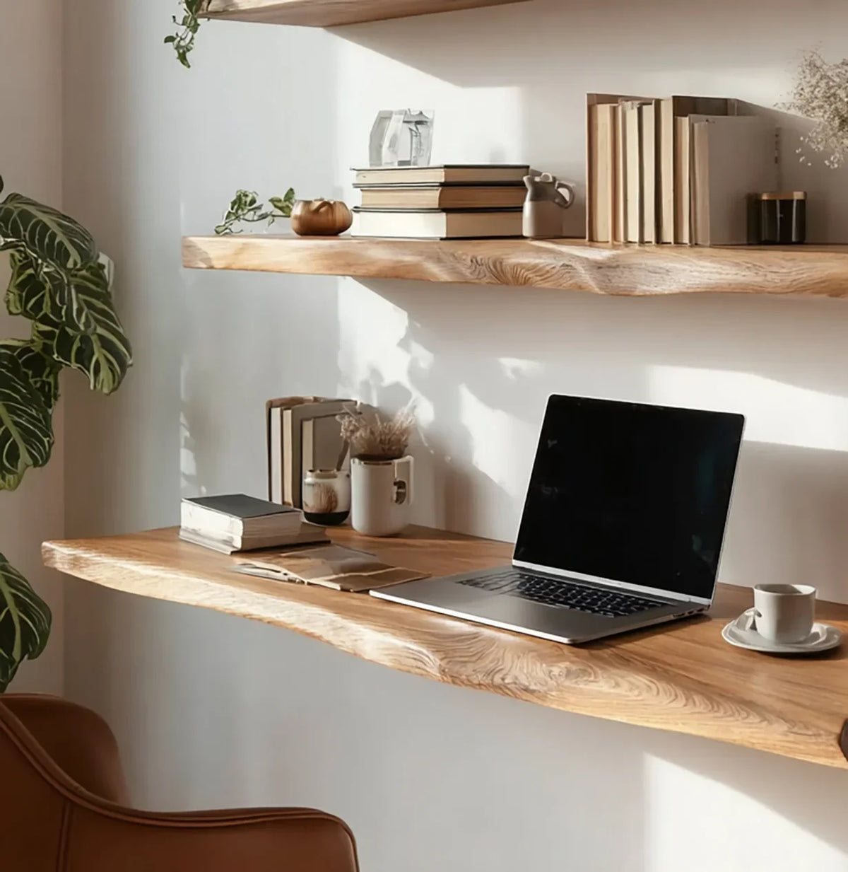 Minimalist wooden floating desk and shelf with laptop, books, plants, and coffee cup in natural light