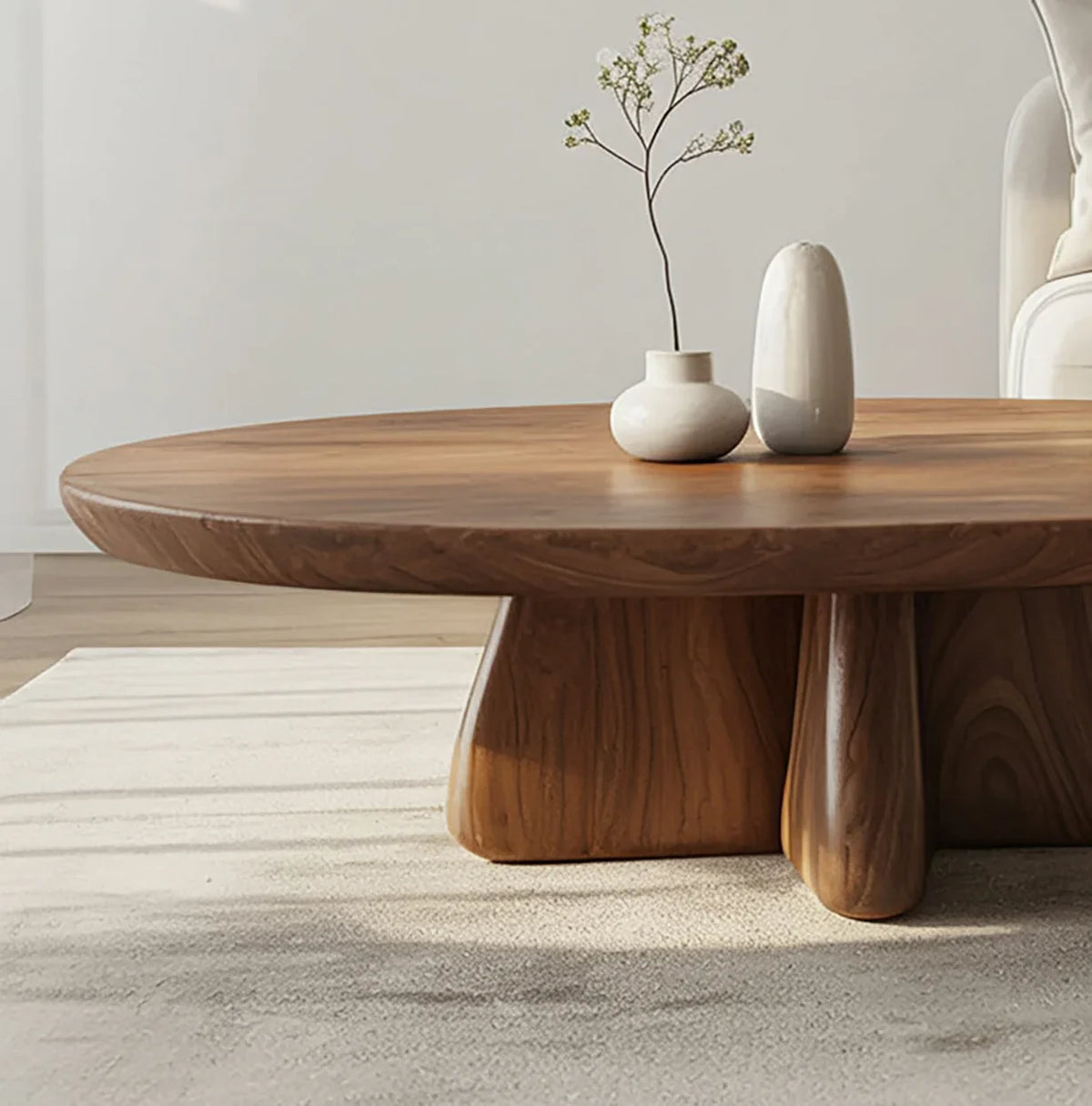 Round solid wood coffee table with natural finish in a modern living room, minimalist decor