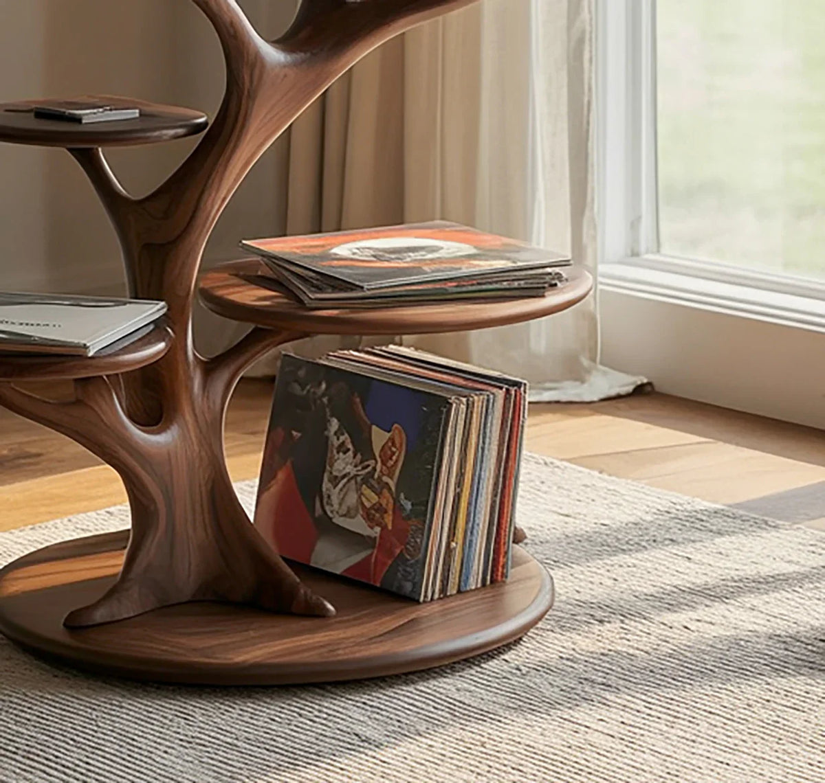 Sculpted solid wood tree bookshelf holding vinyl records and books by a window on a rug.