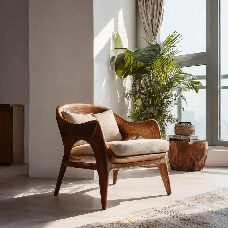 Modern solid wood accent chair with beige cushions in a sunlit living room, near large windows and green indoor plants.